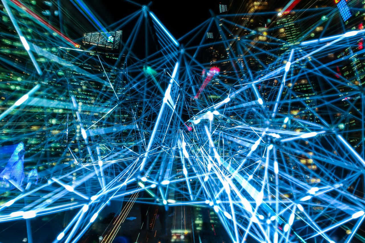 Home Dynamic urban scene showcasing interconnected light trails representing digital communication networks.